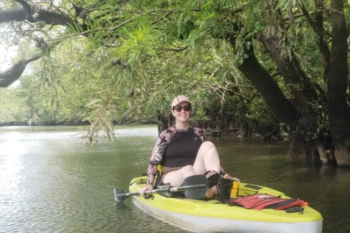 a woman riding on the back of a boat in the water